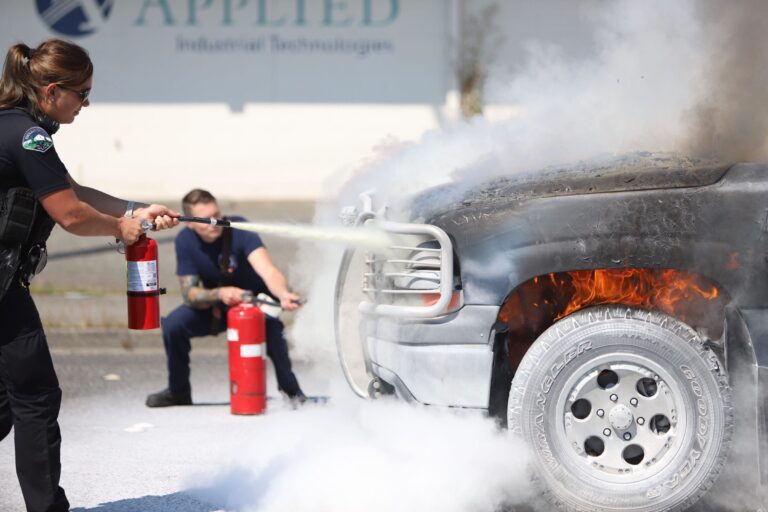 Bellingham Police officers, arriving early on the scene, work to extinguish an engine fire.