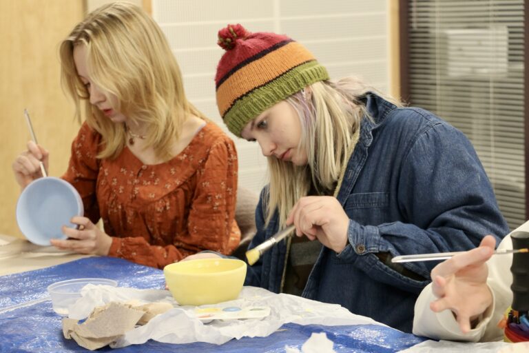 Zoe Norman, right, paints a ceramic bowl during a Youth for the Environment and People club meeting alongside other young attendees.