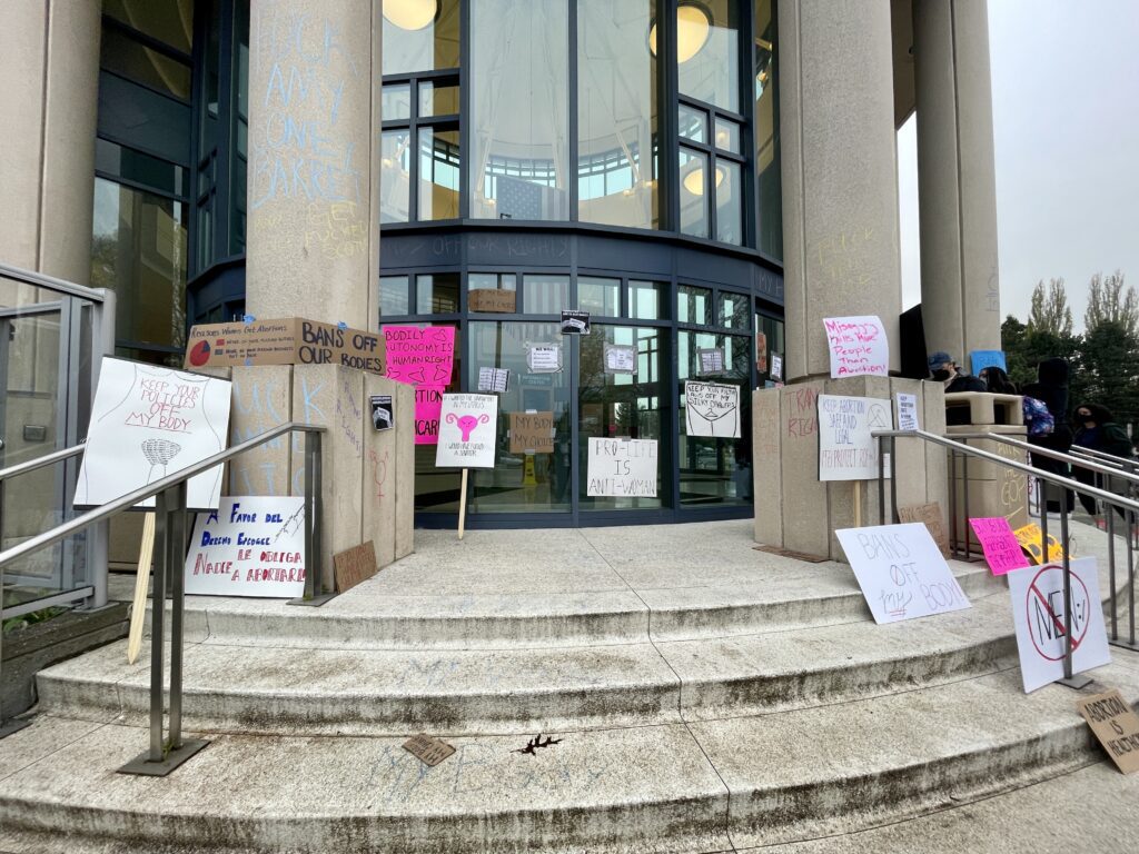 Many protesters left their signs of varying messages and designs at the entrance of the Whatcom County Courthouse.