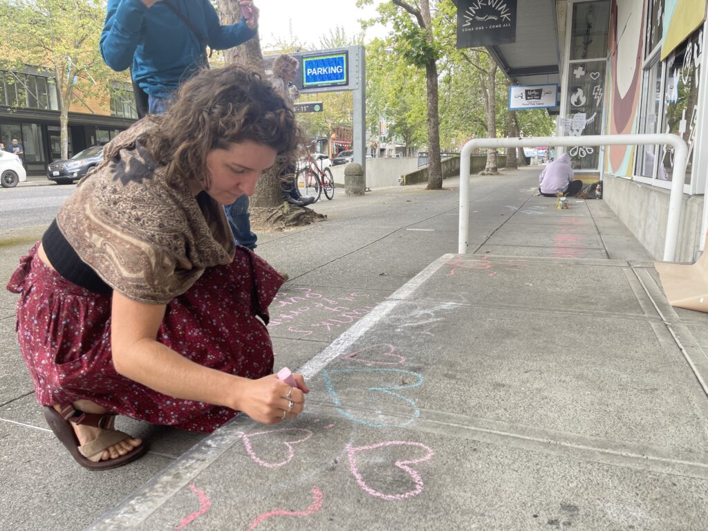 Michelle Meyer draws on the ground with chalk.