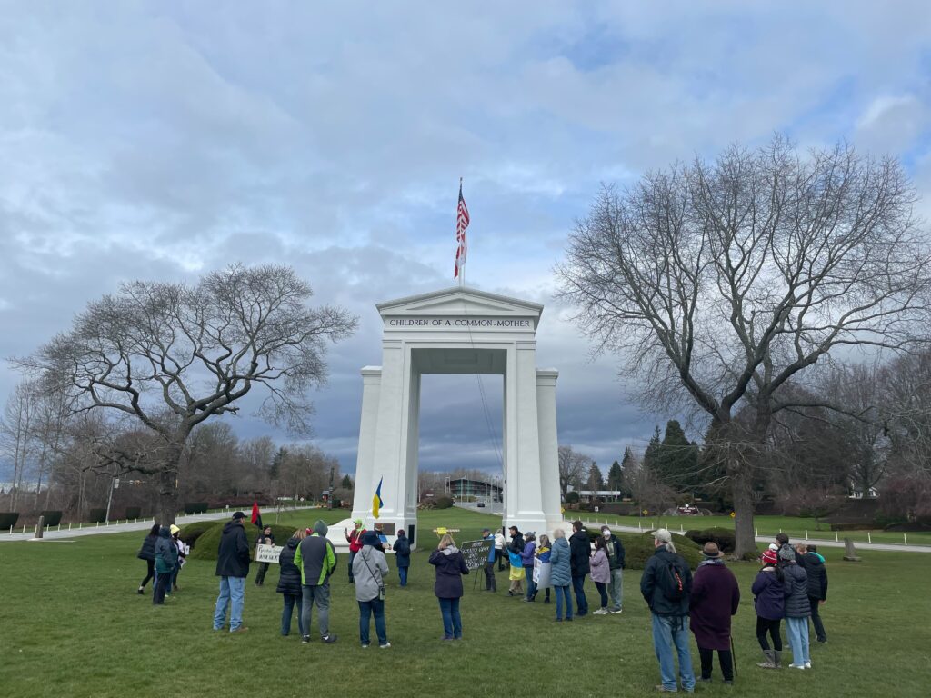 Dozens of people attended a rally at the Peace Arch with flags and signs.