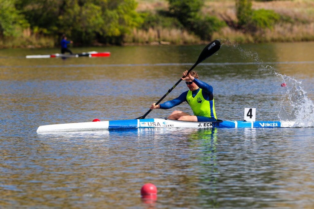 Jonas Ecker competes in the US Canoe Sprint National Team Trials as he lifts a paddle out of the water.