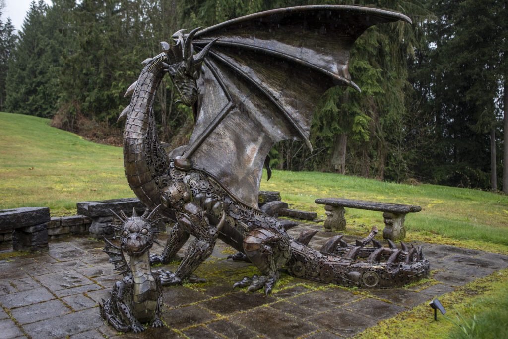 A metal clockwork-like design dragon looms next to a baby version.