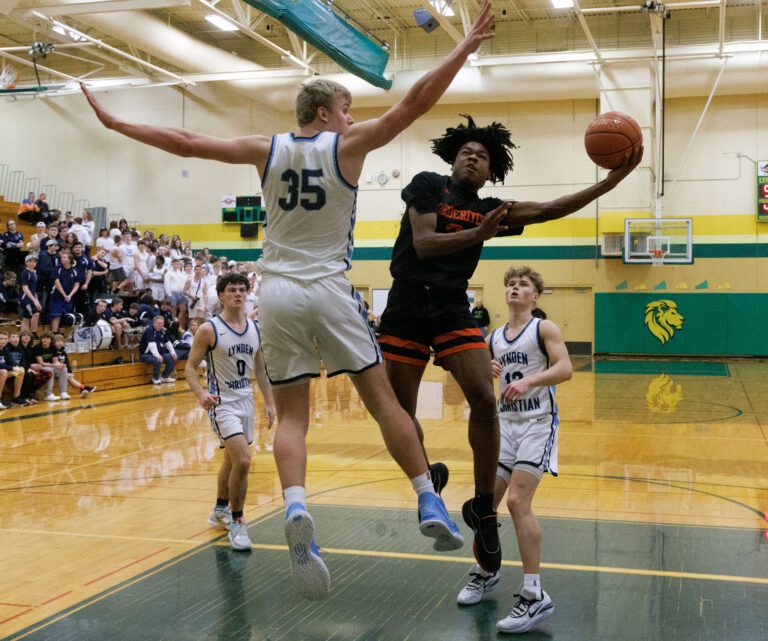 Blaine's Mathew Russ leaps for a shot as a defender leaps with his arms wide to block.