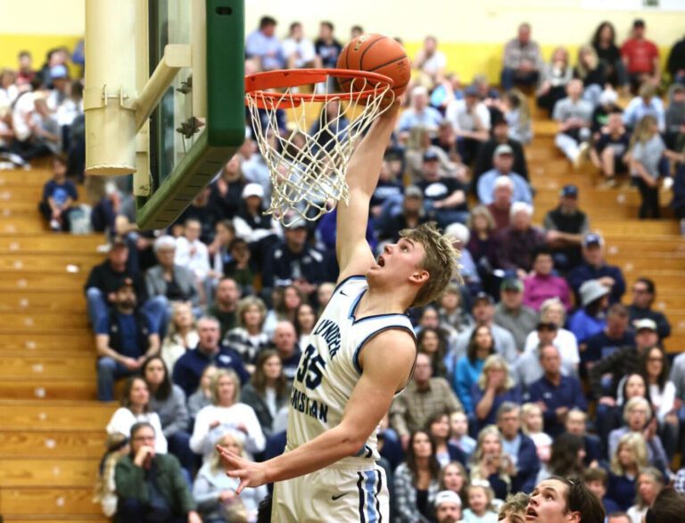 Lynden Christian's Jeremiah Wright leaps for a dunk as spectators react.