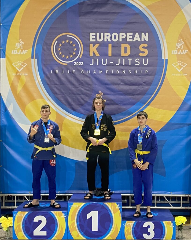 Marcel Senger, middle, poses with his championship medal on the podium next to two competitors.