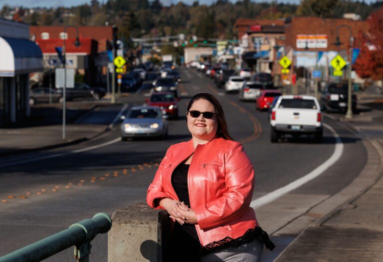 Ferndale Downtown Association’s new Executive Director Melissa O’Brine leans against a platform next to the road.