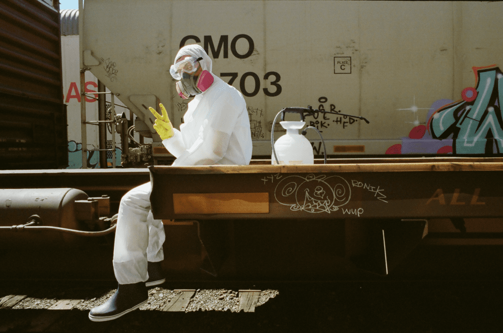 Nodalus flashes a peace sign while dressed in a hazmat suit.