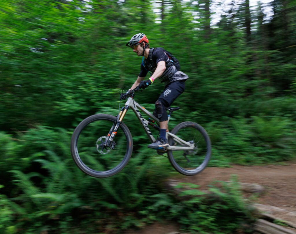 A rider takes mid-air from the steep jump.