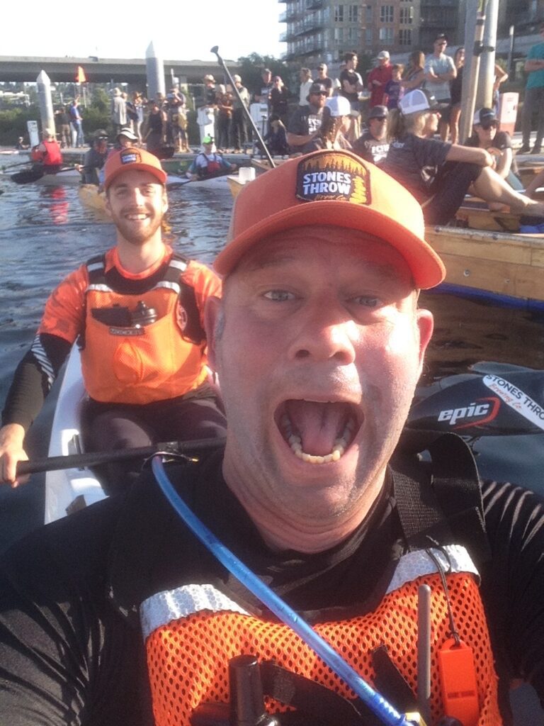 Bart Maupin, front, and teammate Marc Furhmeister visible excited while surrounded by kayakers and attendees.