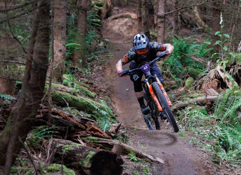 Pro rider Remy Gauvin pedals on the uphill of a trail as he focuses on staying on the narrow path.