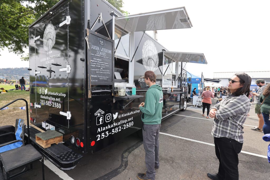 Customers line up at the Alaska Weathervane Scallops truck with their orders.