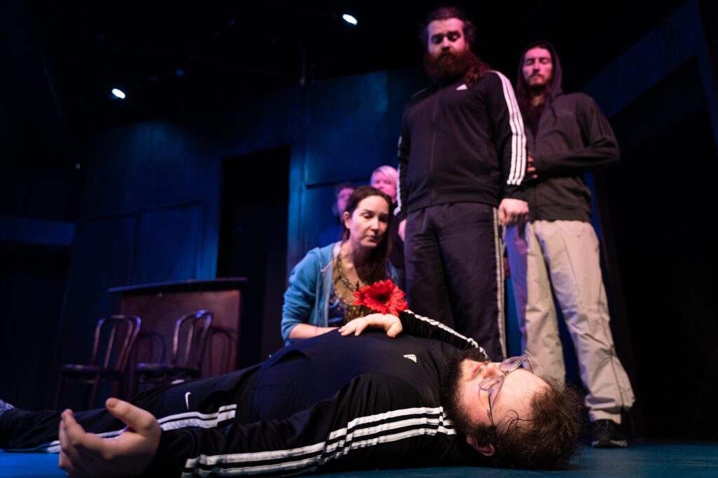 Matthew Balam (on the ground) plays the doomed Hamlet as he pretends to die on stage.