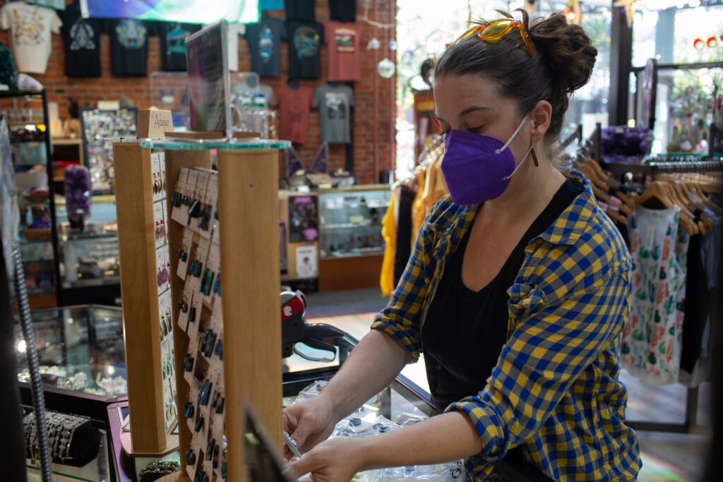 Manager Erika Millage tags and organizes earrings at The Third Planet store.