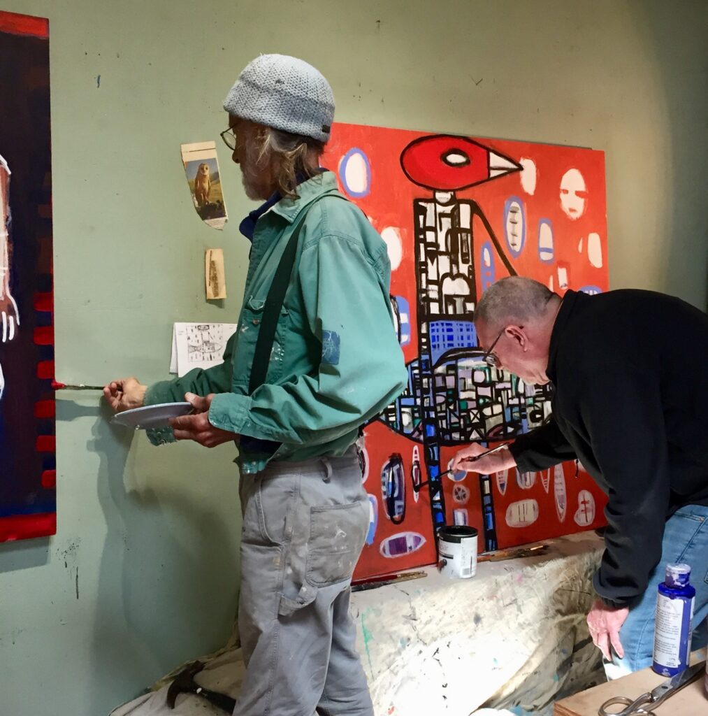 Thomas Wood (left) and R.R. "FishBoy" Clark (right) work together on a painting.