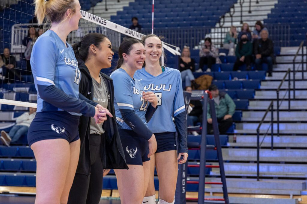 From left, seniors Olivia Fairchild, Malia Aleaga, Gabby Gunterman and Calley Heilborn share a laugh next to the volleyball net.