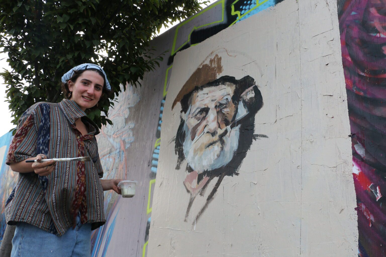 Elinor Hall, 16, talks next to her contribution to the Halloween-themed mural.