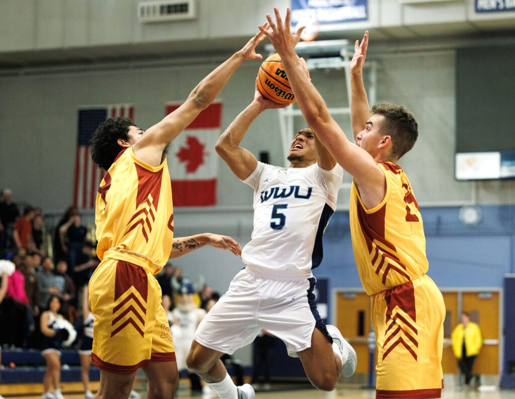 Western Washington University’s D’Angelo Minnis takes a shot while under pressure from two Lincoln University defenders.