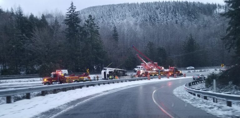 Emergency services surround a semi-truck rollover collision.