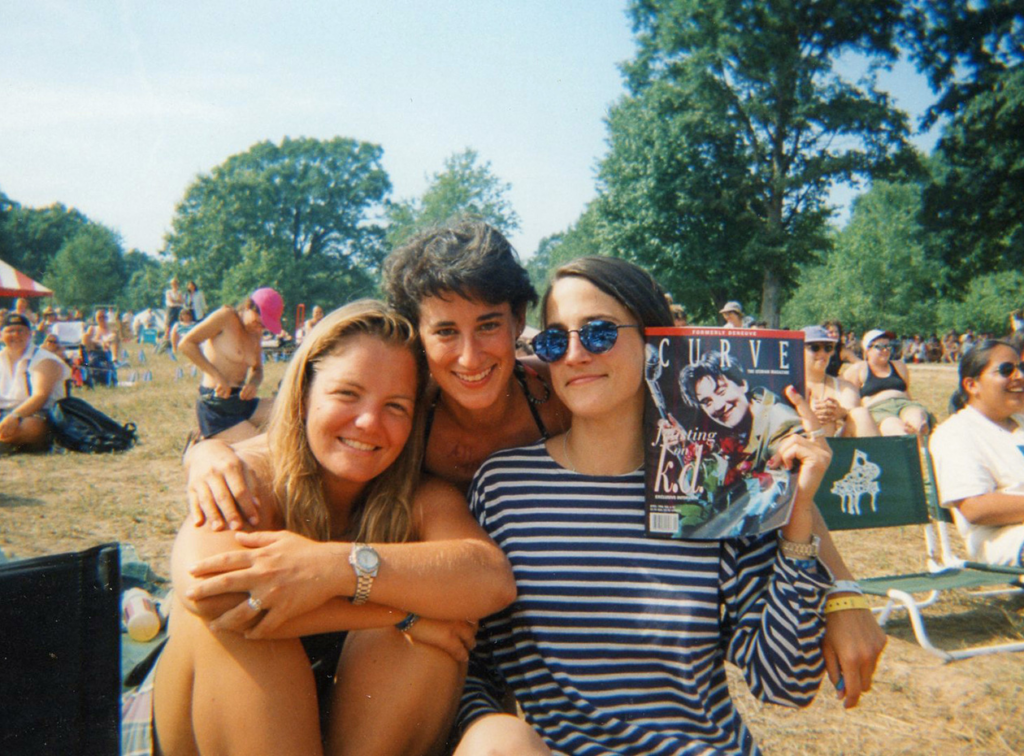 Three young people take a photo as one holds up the curve magazine.