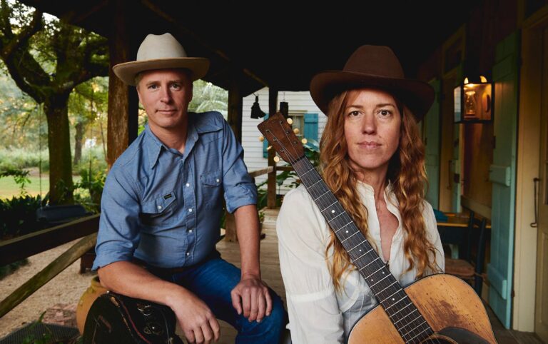 Country duo Reeb & Caleb poses with an acoustic guitar.