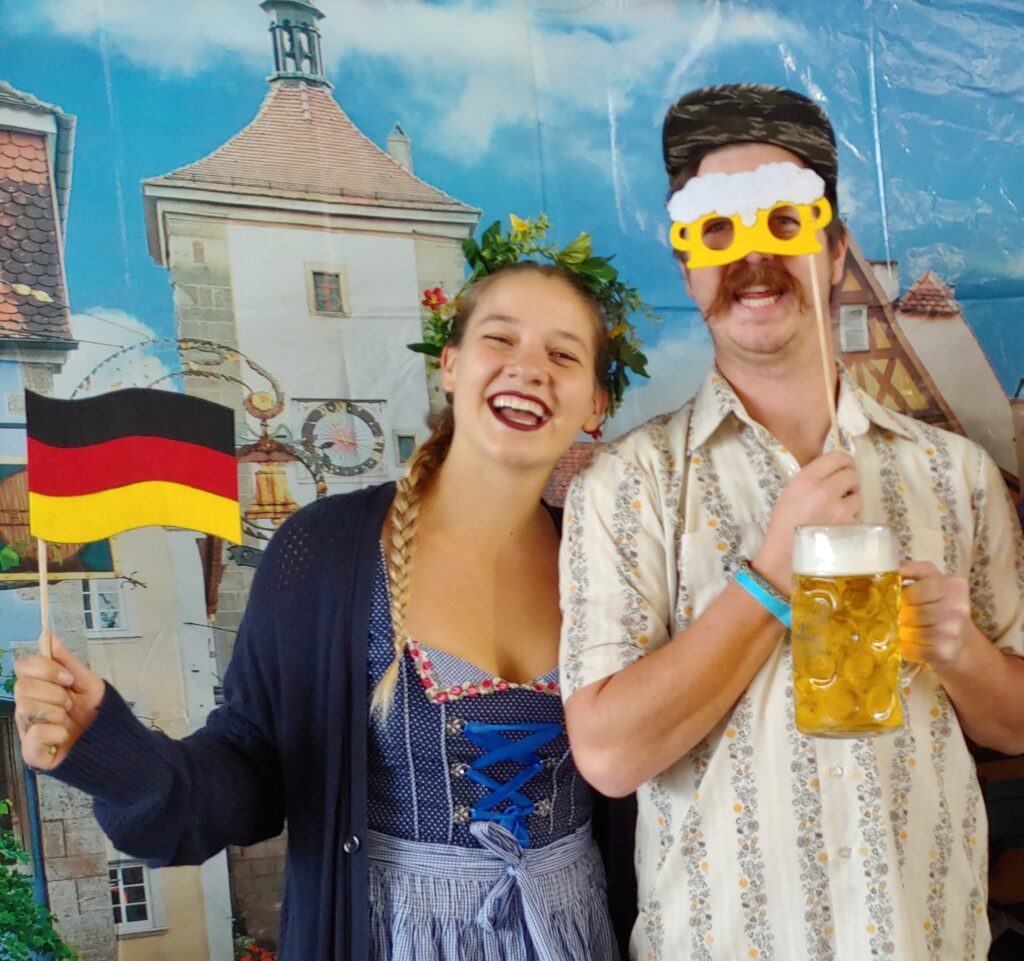 Festival goers take photos with a backdrop, flags, and other props.