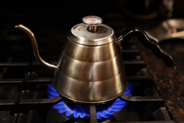 A kettle sits on top of a gas stove.