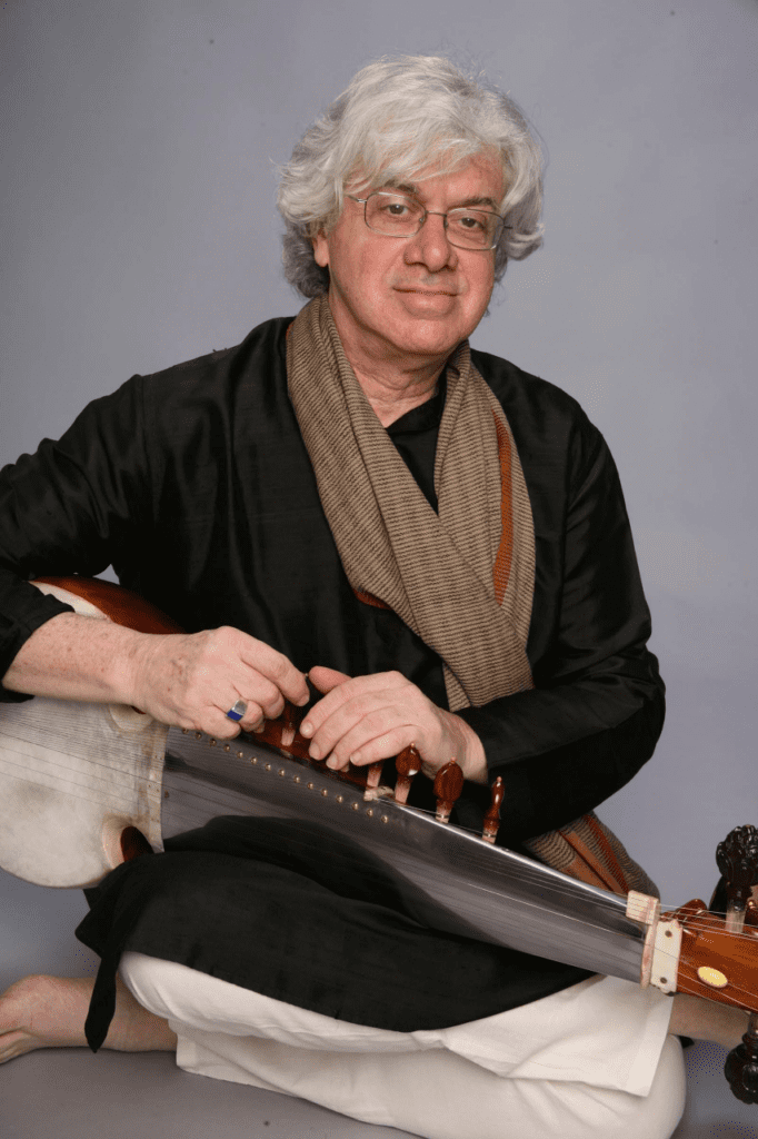 David Trasoff sitting cross-legged with his instrument.