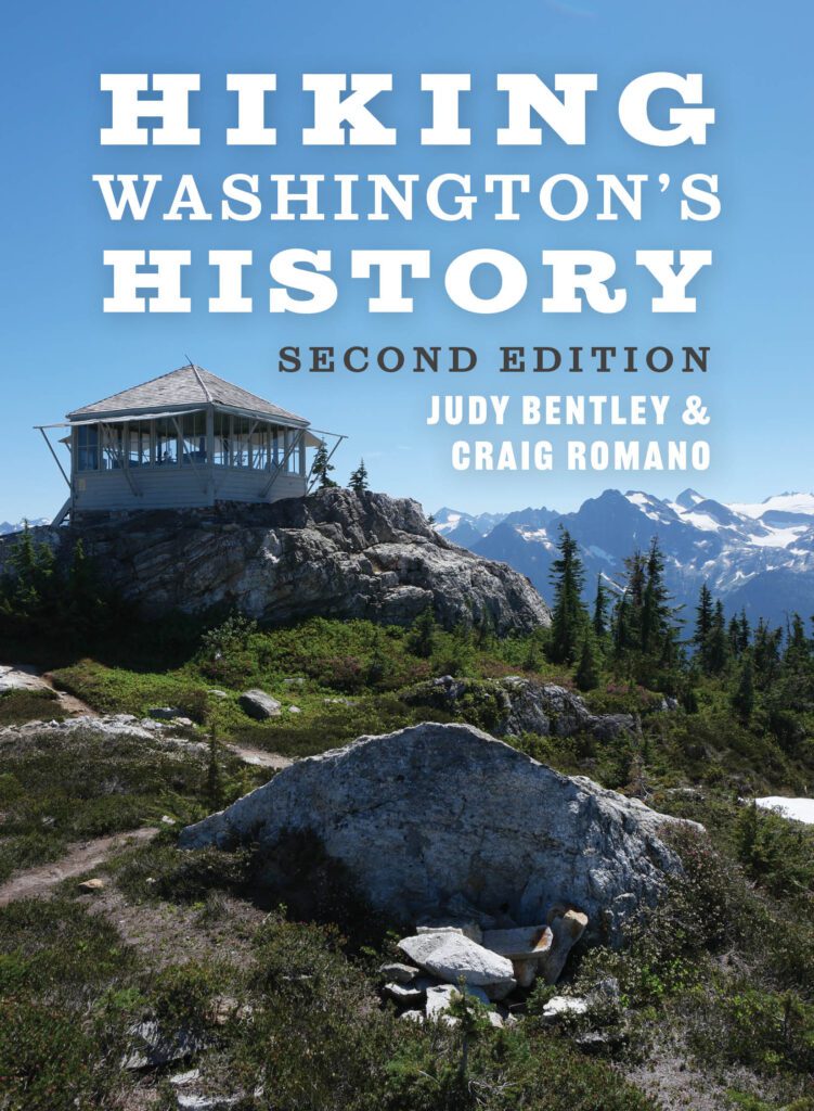 The cover for "Hiking Washington's History" highlights a cabin on top of a mountain.