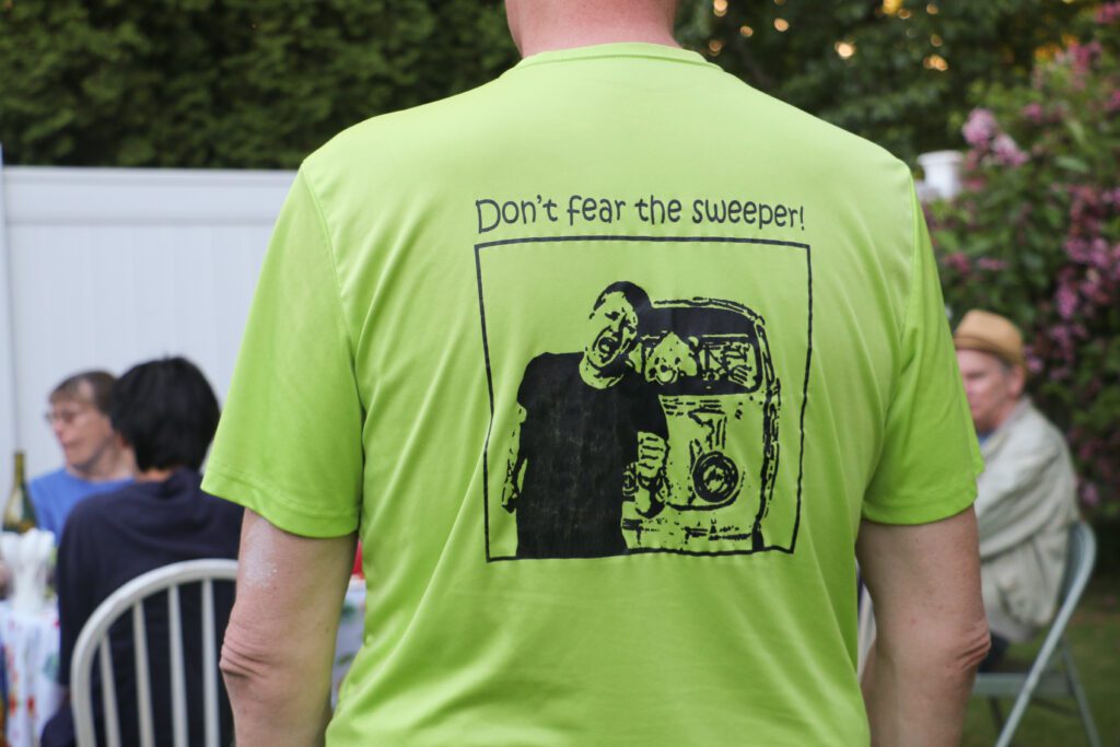 Joe Dobson's team shirt's back has a graphic of Rob Lawrance running away from a sweeper.