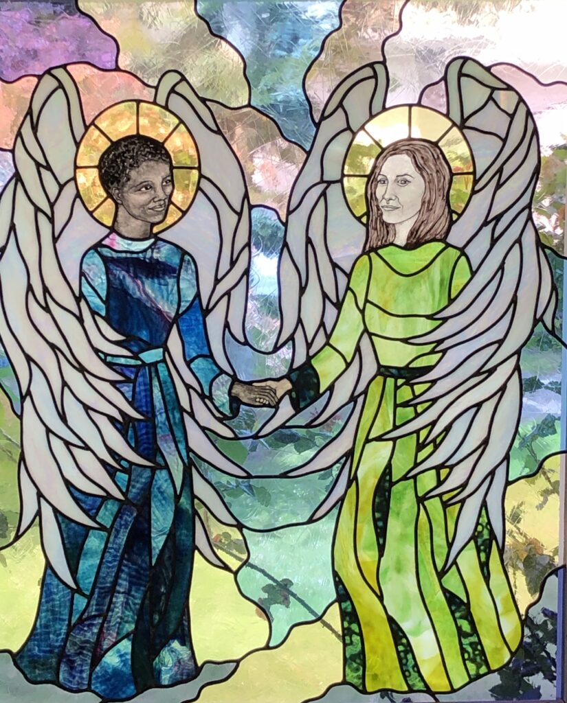 A glass window of two angels holding hands.