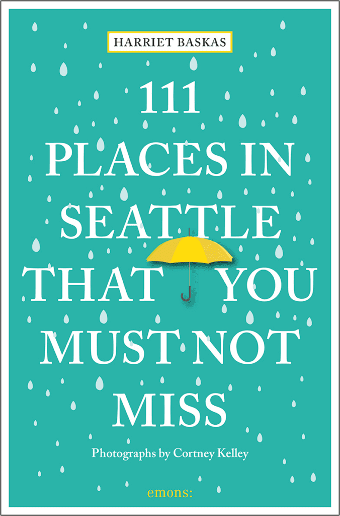 The cover of "111 Places in Seattle That You Must Not Miss" has a bright yellow umbrella with raindrops on the teal background.