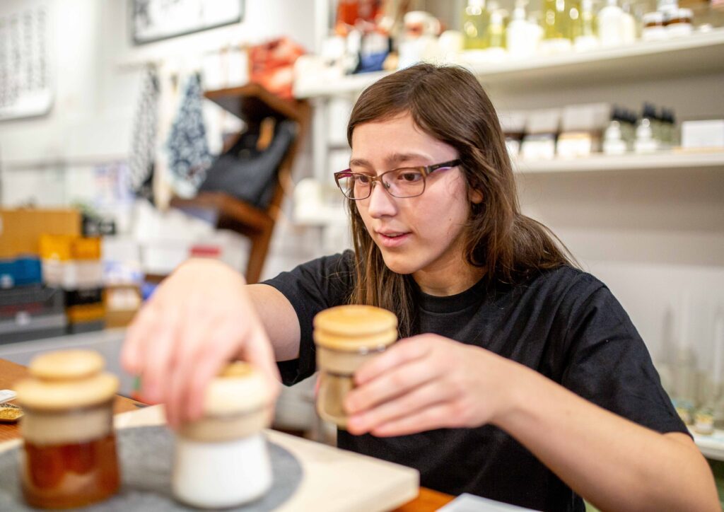 Megan Ostrowski sets up a display of jars.