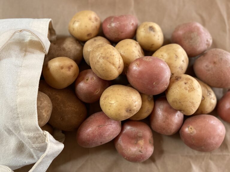 Potatoes taken out of a sack are placed on a table.