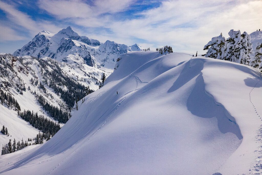 The trail to Huntoon Point covered in softly packed snow ranging from the trail to the mountain peaks.