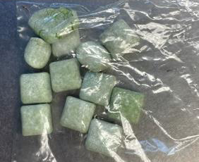 Fake green edibles in a plastic bag on the table.