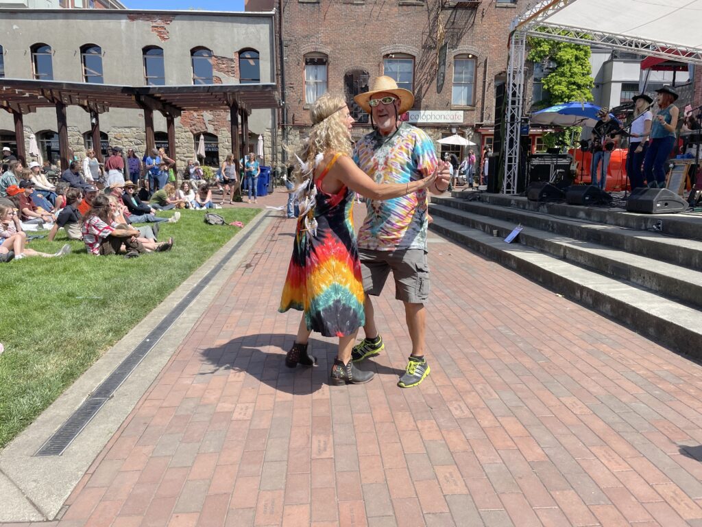 Regina O'Neill, left, and Keith Reid dance to a set by Pacific Twang while dressed in tie-dyed outfits.