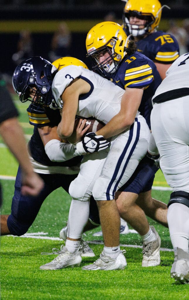 Ferndale’s Lincoln Thomas grabs hold of Glacier Peak quarterback as his teammates help by doing the same.