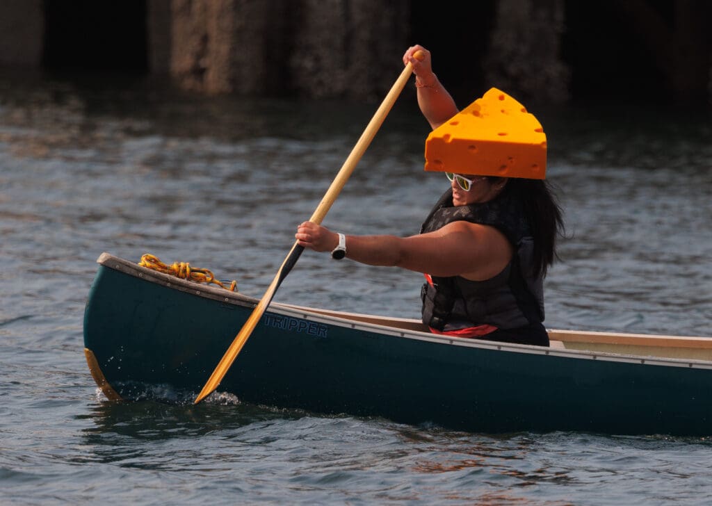 Rhoda Ko wears a cheesehead while paddling during the Bellingham Traverse on Aug. 19 in Bellingham.