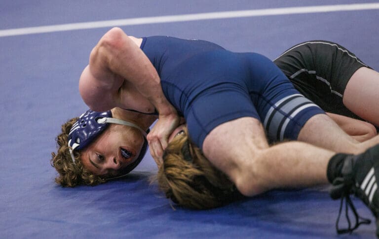 Squalicum’s Jonah Papetti pushes down on Meridian wrestler Carson Siadal’s shoulder to get the pin at the Graham Baker Morin Wrestling Tournament on Dec. 17. It is the first time the tournament has been held since the COVID-19 pandemic.