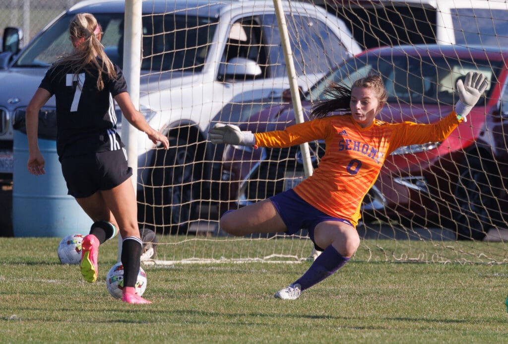 Sehome’s Clarice Hickey revs up her leg to block the shot as a striker gets ready to kick the ball into the goal.