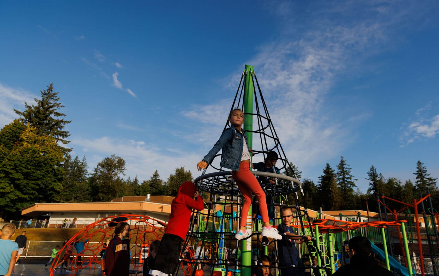 Third-grader Jenna Dawson hangs off a railing and gets a bird's eye view of the new colorful playground.