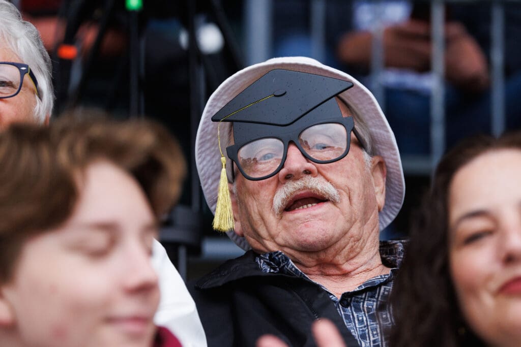 A man wears mortarboard glasses at the Squalicum High School graduation ceremony.