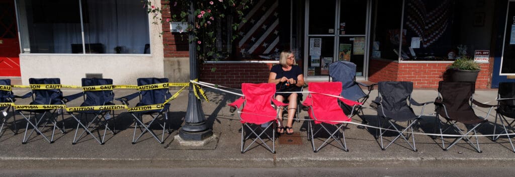 Hilary Bonnette knits while waiting for her daughter to run in the footrace before the parade.