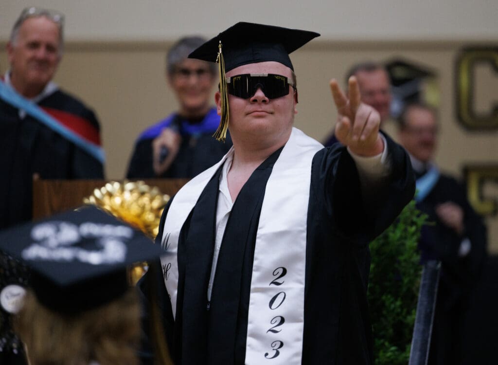Wyatt Dulling dons sunglasses and gives a peace sign after receiving his diploma at the Meridian High graduation ceremony.