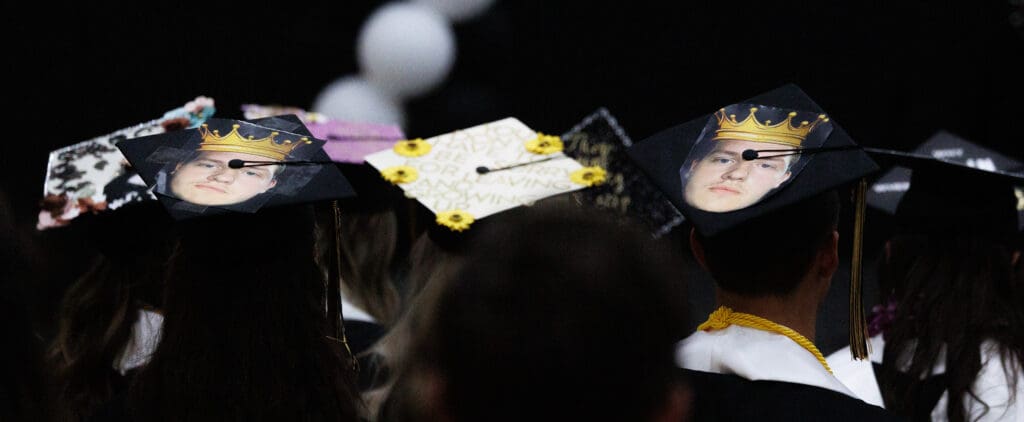 Students sport a photo of fellow senior Cohen Vickers on their mortarboards at Meridian High School's graduation ceremony.
