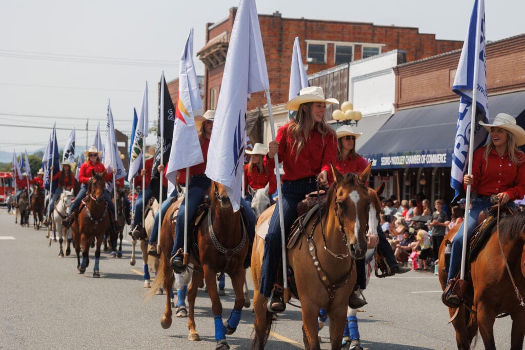 Flag riders parade down the street.