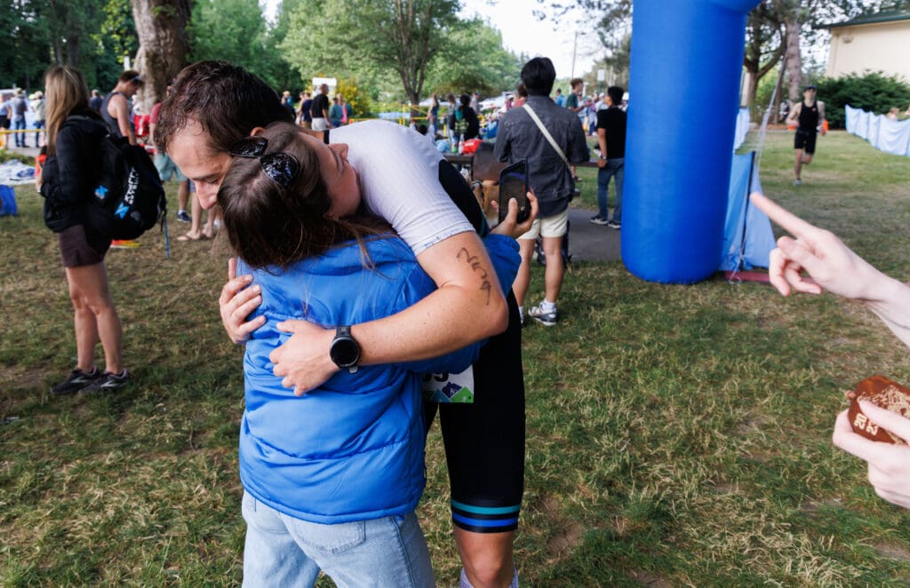 Racer Travis Mundell hugs Eden Nafziger after finishing the Lake Whatcom Triathlon.