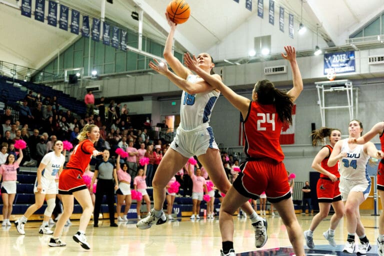 Western Washington University's Brooke Walling leaps to score as a defender tries to block the shot from her side.