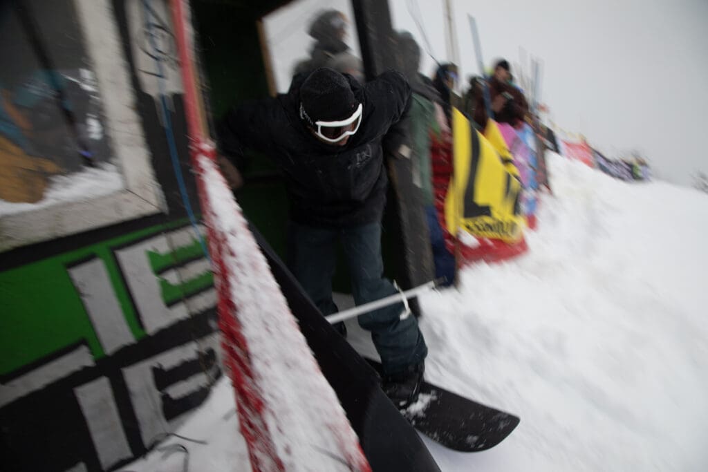 Roy Chand pushes himself off the building to give himself a boost on his snowboard.